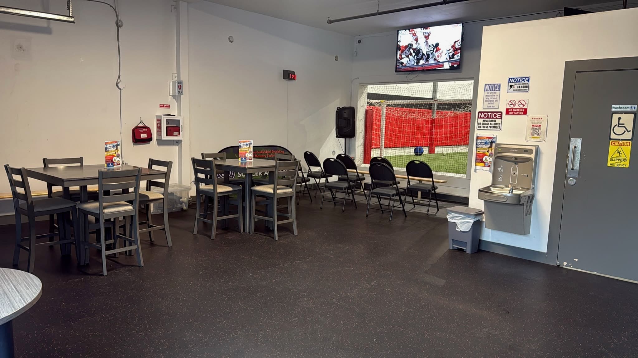 Lobby seating facing a window onto the indoor field