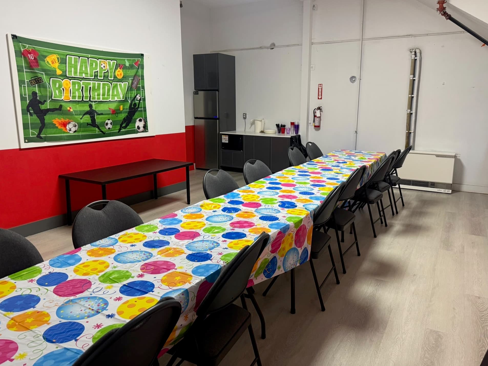 The Full 90 party room set up with long tables under a soccer birthday banner